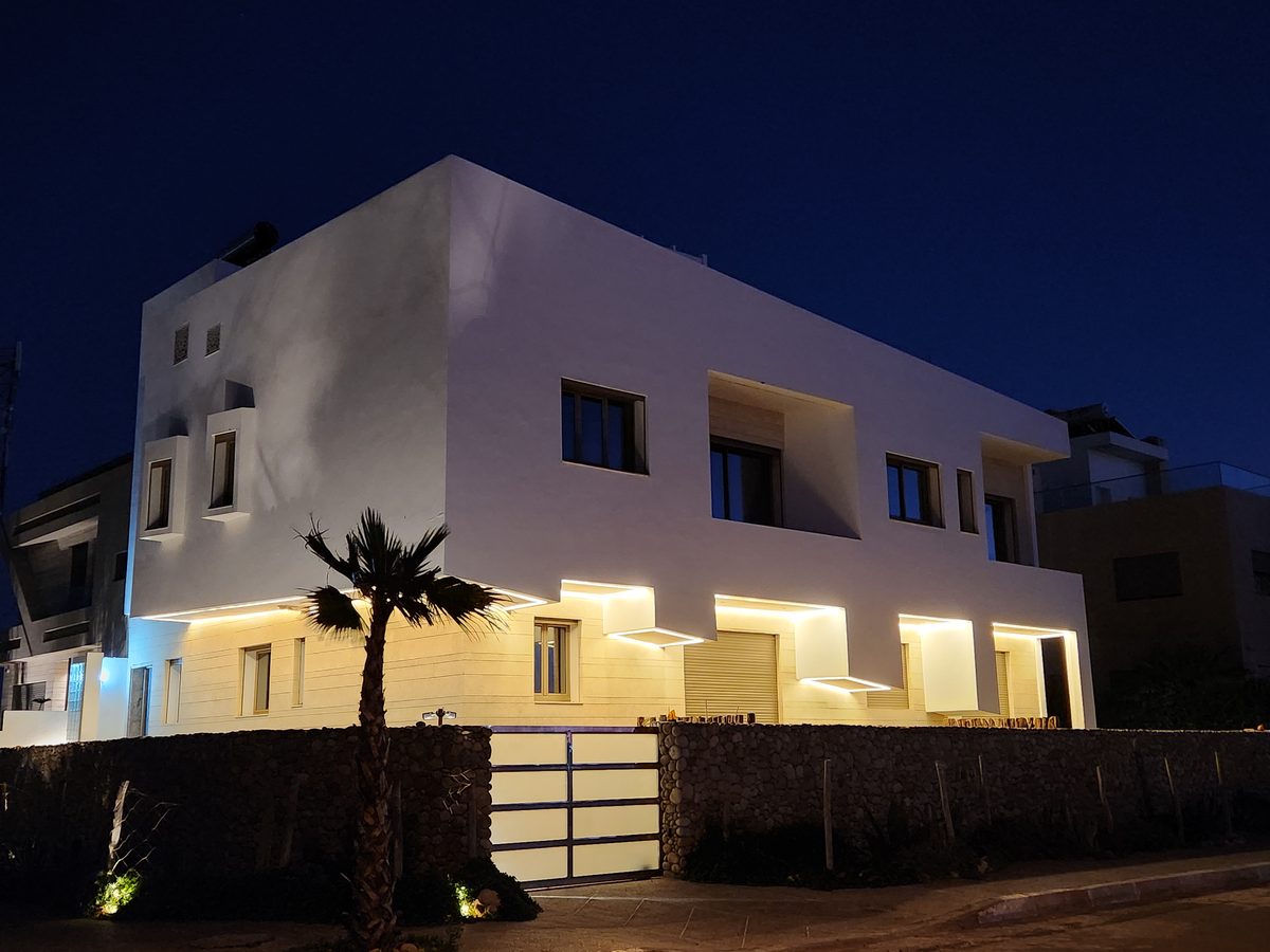 La villa à la tombée du jour — volumes cubiques blancs, lumière chaude sous les auvents